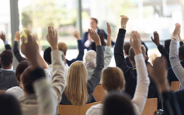 Audiencia participando en una conferencia de liderazgo y desarrollo ejecutivo